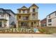 New build home with a stone and tan siding exterior, balcony, and small landscaped front yard at 7276 Waterleaf Trl, Littleton, CO 80125