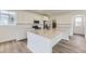 Bright kitchen features white cabinets, stainless steel appliances, quartz counters, and hardwood floors at 7276 Waterleaf Trl, Littleton, CO 80125