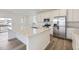 Bright kitchen features white cabinets, stainless steel appliances, quartz counters, and hardwood floors at 7276 Waterleaf Trl, Littleton, CO 80125