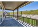 Covered back porch with wood railing and a beautiful view of the green hillside at 20 Leafy Aster Ln, Castle Rock, CO 80104
