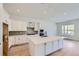 Modern kitchen with white cabinets, stainless steel appliances, large island, and hardwood floors at 20 Leafy Aster Ln, Castle Rock, CO 80104