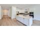 Modern kitchen with white cabinets, stainless steel appliances, large island, and hardwood floors at 20 Leafy Aster Ln, Castle Rock, CO 80104