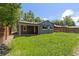 Backyard view of the home featuring a covered patio and lush lawn at 4451 Eliot St, Denver, CO 80211