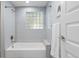 Bright bathroom with a shower-tub combination and a glass block window at 4451 Eliot St, Denver, CO 80211