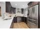 Modern kitchen featuring stainless steel appliances, white quartz countertops, and dark wood cabinets at 4451 Eliot St, Denver, CO 80211