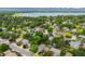 Real estate aerial view showing a suburban neighborhood near a lake and mountains, with tree-lined streets and cozy homes at 4677 S Wolff St, Denver, CO 80236