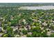 Real estate aerial shot of homes in a green residential neighborhood, showcasing a lake in the distance at 4677 S Wolff St, Denver, CO 80236