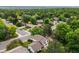 Real estate aerial showcasing a home in a quiet suburban neighborhood with mature trees and a well-maintained landscape at 4677 S Wolff St, Denver, CO 80236