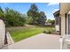 Private backyard featuring a concrete patio, lush lawn, garden bed and mature trees offering a serene outdoor space at 4677 S Wolff St, Denver, CO 80236
