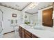 A bathroom with floral wallpaper, oak cabinets and an enclosed shower at 4677 S Wolff St, Denver, CO 80236