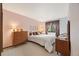 Bedroom with pink walls, carpet flooring, and matching wooden dressers and nightstands at 4677 S Wolff St, Denver, CO 80236