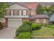 Charming brick home with a two-car garage, well-maintained lawn, and mature landscaping at 4677 S Wolff St, Denver, CO 80236