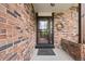 Inviting brick entryway with a screen door and a decorative wreath at 4677 S Wolff St, Denver, CO 80236