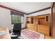 A home office with built-in shelving, an oriental rug and a black executive chair at 4677 S Wolff St, Denver, CO 80236