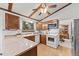 Traditional kitchen with wood cabinets, white appliances, and a view into the dining area at 4677 S Wolff St, Denver, CO 80236