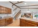 Bright kitchen featuring wood cabinets, granite countertops, a central island, and adjacent staircase at 4677 S Wolff St, Denver, CO 80236