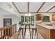 Open kitchen with a breakfast bar, wood accents, and natural light from surrounding windows at 4677 S Wolff St, Denver, CO 80236