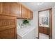 Functional laundry room with wood cabinets and a washer/dryer, leading to a bathroom at 4677 S Wolff St, Denver, CO 80236
