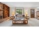 Inviting living room with a brick fireplace, built-in bookshelves, and a large window at 4677 S Wolff St, Denver, CO 80236