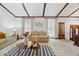 Bright and airy living room with beamed ceilings, a patterned rug, and comfortable seating at 4677 S Wolff St, Denver, CO 80236