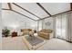 Spacious living room with beamed ceilings, neutral decor, and plenty of natural light at 4677 S Wolff St, Denver, CO 80236