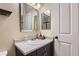 Functional bathroom featuring a single sink vanity, dark cabinets, large mirrors, and a shower at 8445 S Holland Way # 205, Littleton, CO 80128