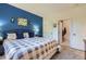 This bedroom features a queen size bed, gray and white bedding, a blue accent wall and ample closet space at 8445 S Holland Way # 205, Littleton, CO 80128
