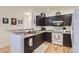 Efficient kitchen with granite counters, wood cabinets, modern appliances, and hardwood flooring at 8445 S Holland Way # 205, Littleton, CO 80128