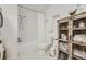 Bathroom with a vintage storage cabinet, modern sink, and tub with shower at 947 S Yates St, Denver, CO 80219