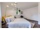Bright bedroom with white walls, a large window, hardwood floors, and a statement lamp at 947 S Yates St, Denver, CO 80219