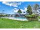 Inviting outdoor pool is fenced and features solar panels, surrounded by lush green lawns and landscaping at 7665 E Eastman Ave # 210, Denver, CO 80231