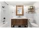 Charming bathroom featuring subway tile, rustic vanity with storage, and updated fixtures at 1253 Uinta St, Denver, CO 80220