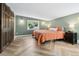 Bright bedroom features stylish herringbone floors, a comfortable bed, and bright natural lighting at 1253 Uinta St, Denver, CO 80220