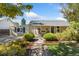 Charming single-story home featuring a well-manicured yard and welcoming front porch with seating at 1253 Uinta St, Denver, CO 80220