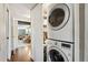 Convenient laundry area with stacked washer and dryer next to linen storage and with laminate flooring at 1253 Uinta St, Denver, CO 80220