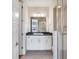 Well lit bathroom with a white vanity, black countertop, chrome fixtures, and a glass enclosed shower at 3654 Penang Dr, Castle Rock, CO 80109