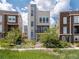 Modern three-story townhome with a stone facade, balcony, and landscaped front yard at 3654 Penang Dr, Castle Rock, CO 80109