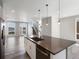 Modern kitchen area showcasing an island with a sink, wood floors, and access to the staircase at 3654 Penang Dr, Castle Rock, CO 80109