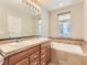 Bright bathroom with double vanity, soaking tub, and neutral tiled surround at 453 S Quay Street, Lakewood, CO 80226
