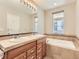 Bright bathroom with double sinks, soaking tub and travertine tile at 453 S Quay Street, Lakewood, CO 80226