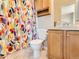Well-lit bathroom with colorful shower curtain and convenient vanity storage at 453 S Quay Street, Lakewood, CO 80226