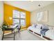 Sunny bedroom featuring a bright yellow accent wall, window with blinds, and a trundle daybed at 453 S Quay Street, Lakewood, CO 80226