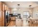 Open kitchen with stainless steel appliances, wood cabinets, a center island, and a dining area with access to the balcony at 453 S Quay Street, Lakewood, CO 80226