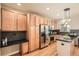 Kitchen featuring wood cabinets, stainless steel appliances, black countertops, and sleek backsplash at 453 S Quay Street, Lakewood, CO 80226
