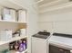 Bright laundry room featuring a modern washer and dryer plus ample shelf space at 453 S Quay Street, Lakewood, CO 80226