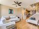 Open concept living area with hardwood floors, a sectional sofa, and a staircase leading to the upper level at 453 S Quay Street, Lakewood, CO 80226