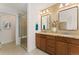 Well-lit bathroom featuring double sinks, granite countertops, and a modern glass shower at 671 Robert St, Longmont, CO 80503