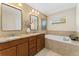Relaxing bathroom with dual sinks, granite countertops, and a luxurious soaking tub at 671 Robert St, Longmont, CO 80503