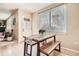 Cozy dining area features a wooden table and bench with a view through a large window at 12185 S Grass River Trl, Parker, CO 80134