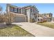 Attractive home featuring gray siding, stone accents, attached garage, and concrete driveway at 12185 S Grass River Trl, Parker, CO 80134